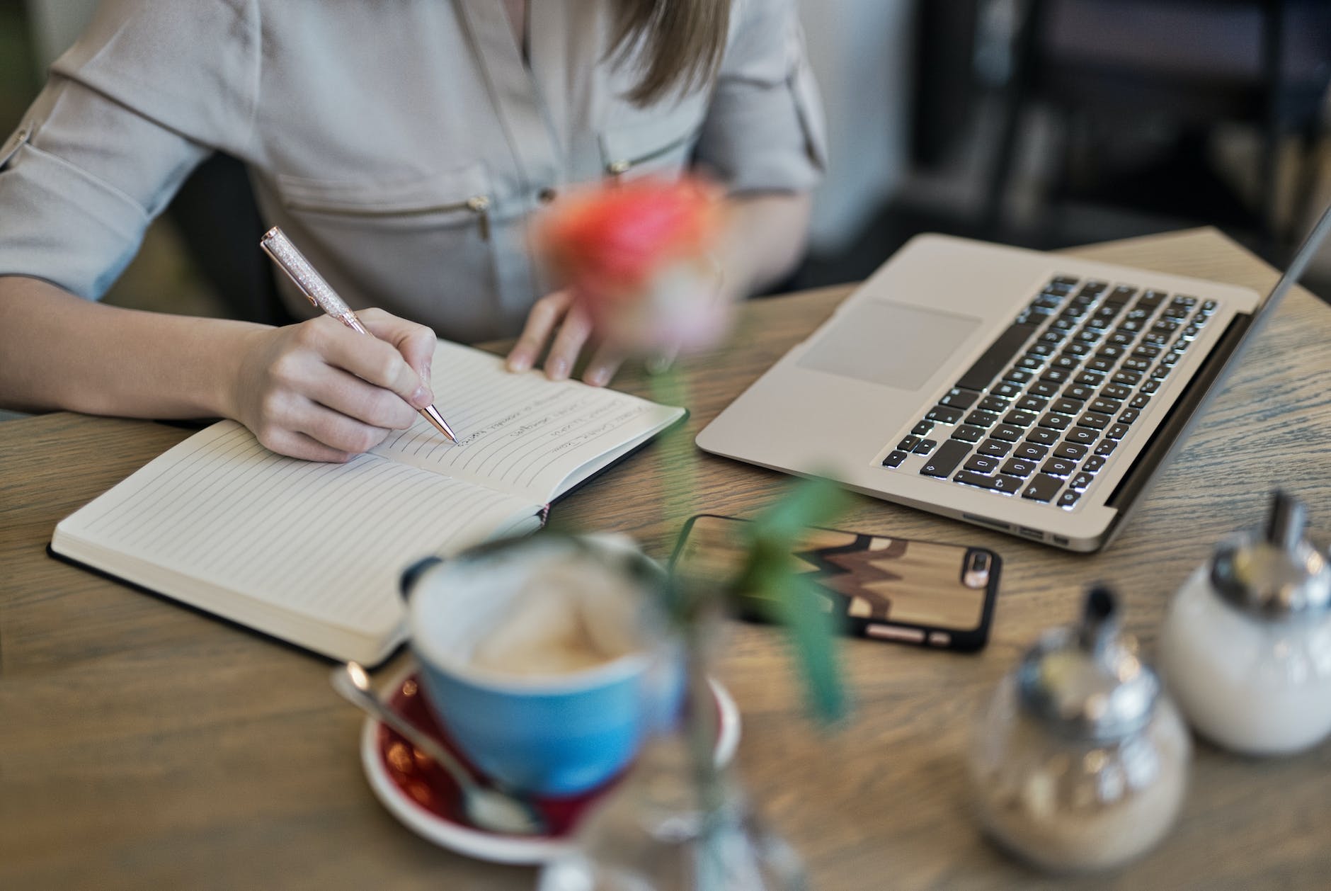 7 Surefire Ways To Increase Your Website Traffic 1 person writing on a notebook beside macbook